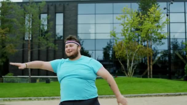 Beau jeune homme obèse devant la caméra souriant grand et faisant un entraînement aérobie dur, il est très excité — Video