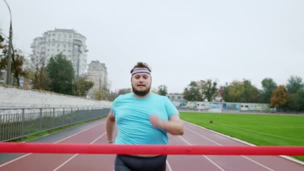 A fiatal elhízott srác le akarja adni a súlyát, és boldogan és izgatottan rohan a maratonra. Megérkezett a célvonalhoz a kamera előtt. — Stock videók