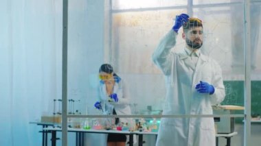Karizmatik bilim adamı biyokimya laboratuarında şeffaf bir tahta kullanarak antivirüs aşısının kimyasal formülünü yazarken asistanı da bazı kimyasal reaksiyonlar yapıyor. Atış açık.