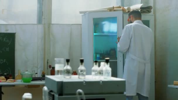 사람 이 자신의 실험에 집중하고 있는 생화학 실험실 과학자는 제약 산업 과 생명 공학 연구소의 테스트 개념을 끝내기 위해 유리관에 약간 의파란 액체를 갖다 놓는다. — 비디오