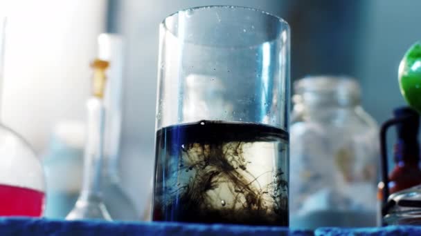 Details in the chemistry lab chemical reaction of a flask full of black substance closeup taking video — Stock Video