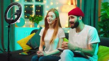 Genç hevesli çift tüm sosyal medya hesapları için canlı yayın yapıyor. Akıllı telefon ve ışık halkası kullanarak sohbet ediyorlar ve video kaydediyorlar.