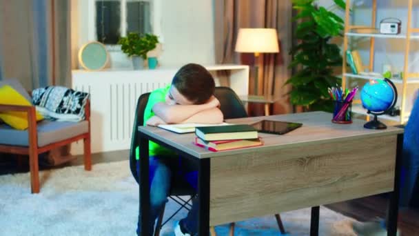 В детской комнате грустный маленький мальчик лежал на столе, ожидая, что его сестра пришла, чтобы сделать домашнее задание вместе счастливы, что они начинают школьное задание вместе — стоковое видео