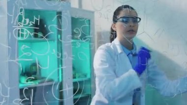 Kameraman kadın bilim adamına yakın çekim, kimya laboratuvarında yoğunlaşan saydam tahtaya kimyasal formülü yazdı. 4k