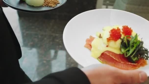 In een modern restaurant met Europese keuken hebben twee dames een lunchpauze, de chef brengt het heerlijke eten naar de tafel — Stockvideo