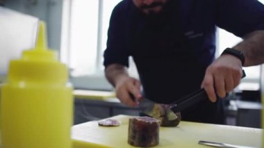 Main chef take a piece of cooked meat and cut off in front of the camera in the professional kitchen restaurant