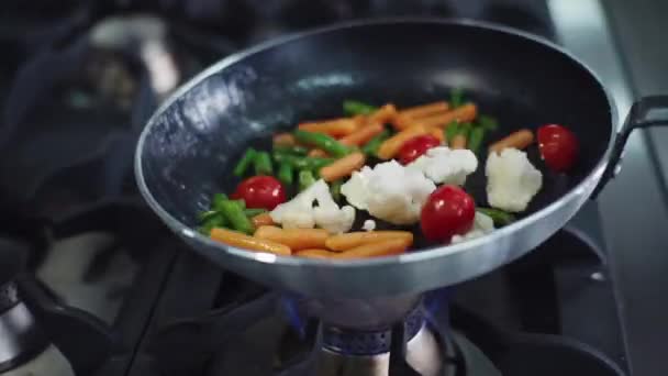 Primer plano de la cámara una colorida sartén wok llena de verduras preparándose en el restaurante de cocina profesional — Vídeos de Stock