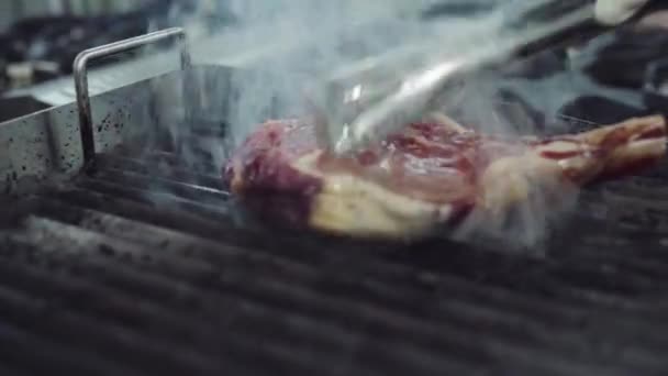 Перед камерой на профессиональной кухне шеф-повар готовит большой бифштекс — стоковое видео