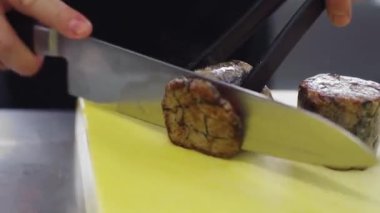 Delicious food prepared by the main chef cutting in front of the camera some juicy meat