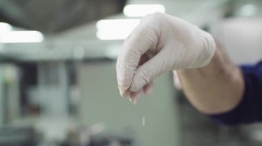 Closeup to the camera main chef of restaurant in the kitchen take some see salt and drop on the food he wearing protective gloves