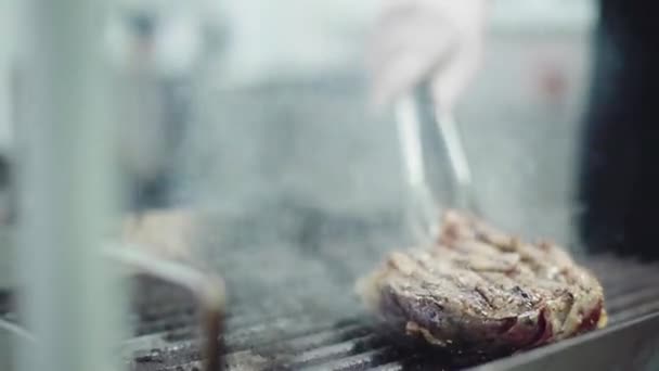 Delicious beef steak cooking in front of the camera on professional grill by the main chef of restaurant — Αρχείο Βίντεο