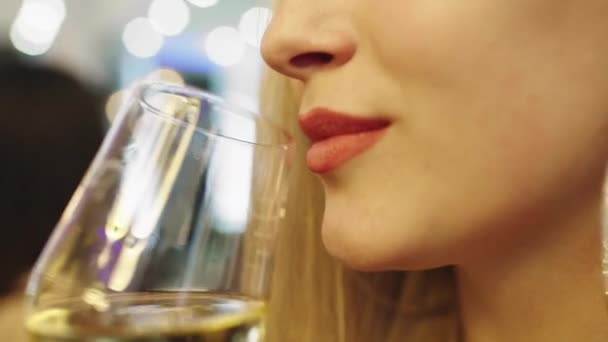 Vor der Kamera das Porträt einer Dame, die ein Glas Champagner nimmt und ein paar Tropfen trinkt, genießt sie die Zeit im Restaurant — Stockvideo