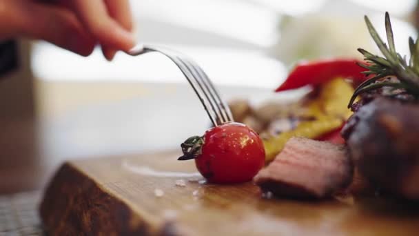 Dinner time closeup to the camera a man take the knife and start to eat his plate of delicious food — Wideo stockowe