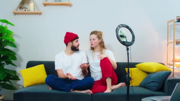 Live stream at home for social media account couple sitting on the sofa they talking in front of the camera using a light ring for this — Αρχείο Βίντεο