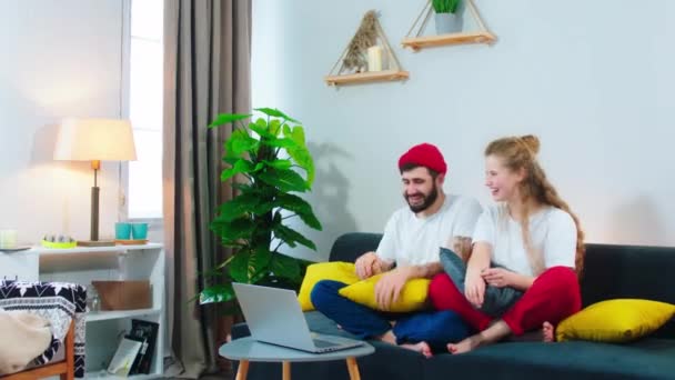 In the modern living room smiling large couple watching a movie on the laptop they feels very excited and happy while sitting on the sofa — Stockvideo