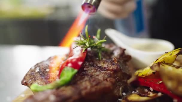 Pistola de fuego profesional en la cocina del restaurante chef principal puso un poco de fuego sobre el plato de comida — Vídeos de Stock