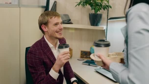 Lachende leuke jongen en zijn collega dame in het kantoor werknemer ze nemen wat koffie en hebben een korte discussie in de pauze — Stockvideo