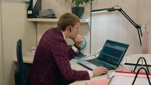 Concentrado gerente de escritório de trabalho homem em seu local de trabalho ele usando um computador para fazer seus planos — Vídeo de Stock