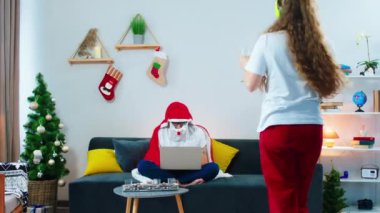 Evdeki kanepede mutlu ve çekici bir bayan iki kadeh şampanya alıp erkek arkadaşına geldi ve Noel zamanı dizüstü bilgisayarında Noel Baba battaniyesi giyen bir adamın filmini izledi.