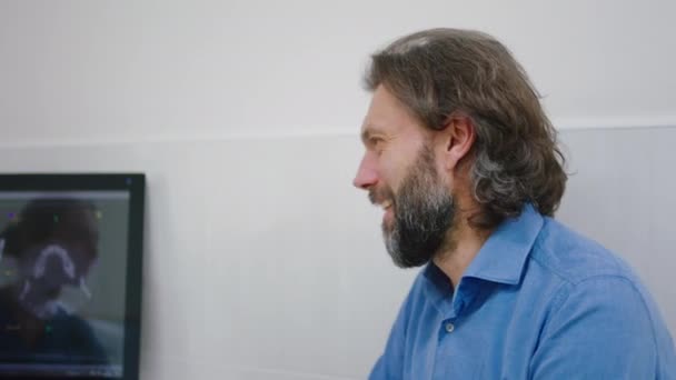 카메라 앞에서 카리스마있는 성인 남자가 큰 치과 의사에게 미소를 지으며 컴퓨터를 보면서 치아 스캔 결과에 대해 함께 이야기하고 있다. ARRI 알렉사 주사 — 비디오