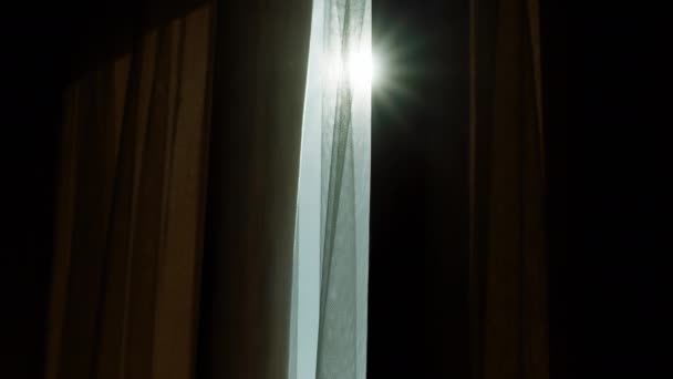 Un primer plano del sol brillando a través de gruesas cortinas de color crema. Disparo en ARRI Alexa Mini. — Vídeo de stock