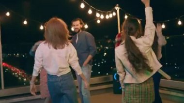 Bir grup çok ırklı insan akşamları birbirlerine beşlik çakar ve arkadaşlarıyla şampanya içerek eğlenirler. ARRI Alexa Mini 'de çekilen.