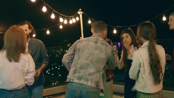 Leende stora glada vänner möter en fest på terrassen de kramar varandra och känner upphetsad — Stockvideo