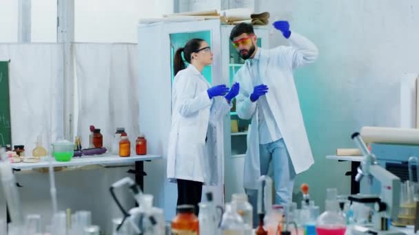 생화학 실험실의 두 동료 과학자가 매우 농축 된 연구를 위해 유리 튜브와 화학 액체를 사용하는 실험을 하고 있습니다. ARRI 알렉사 미니 촬영. — 비디오