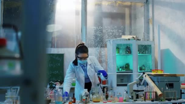 Kimya laboratuarındaki konsantre çalışan kadın cam küvetlerdeki kimyasal maddeleri karıştıran bir kimyasal test yaptı. ARRI Alexa Mini 'de çekilen. — Stok video