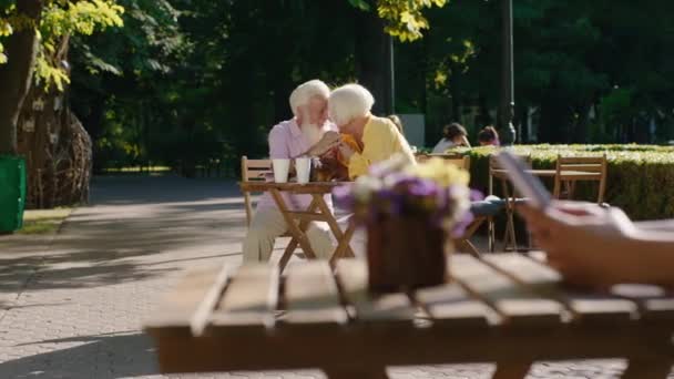 Pareja de ancianos guapos muy románticos con una gran sonrisa acelerando un buen rato juntos se abrazan en la cafetería. 4k — Vídeos de Stock