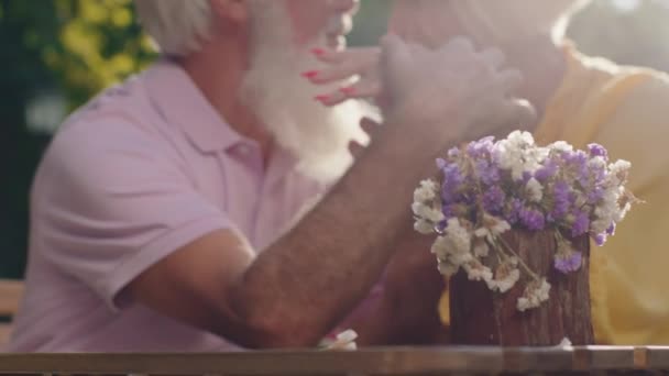 Sehr charismatisches altes Pärchen mitten im Park vor dem Café beschleunigt die gemeinsame romantische Zeit — Stockvideo