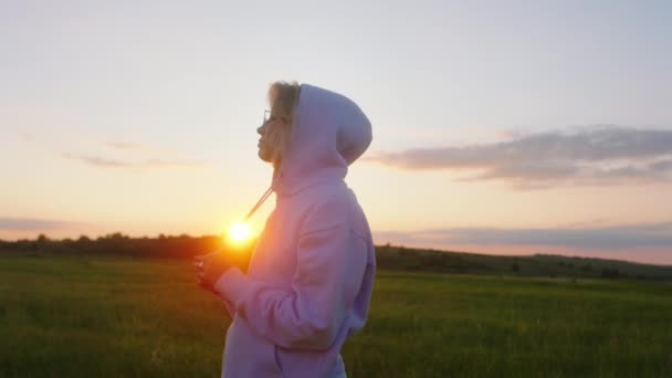 Bella giovane femmina in mezzo a un grande campo al tramonto godersi il momento da sola nella natura — Video Stock