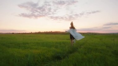 Spor kıyafetleriyle hızla koşan kadın gün batımında özgürlüğünü hissediyor. Harika bir video kaydı.