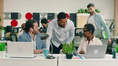 Büyük, parlak, modern bir ofiste, üç meslektaştan oluşan bir grup iş hakkında küçük bir sohbet yapıyorlar.