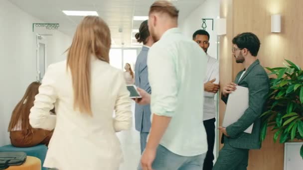 Μια ομάδα τριών όμορφων εργατών με γένια κάνουν μια συζήτηση στο διάδρομο, ενώ πολύς κόσμος περνάει από δίπλα τους. 4ια — Αρχείο Βίντεο