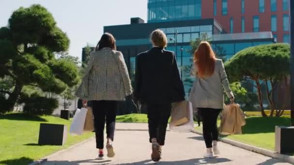 Día soleado en el centro de la ciudad al lado de la construcción moderna grupo de mujeres caminando por la calle después de una buena compra que se reúnen con un colega de oficina carismático negro en el traje. 4k — Vídeos de Stock