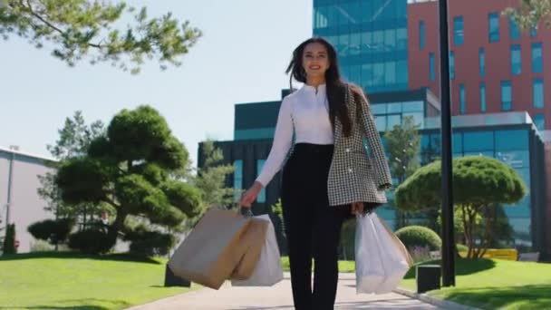 Bonne journée shopping pour une employée de bureau avec des sacs écologiques marchant dans la rue arrière-plan haut centre commercial — Video