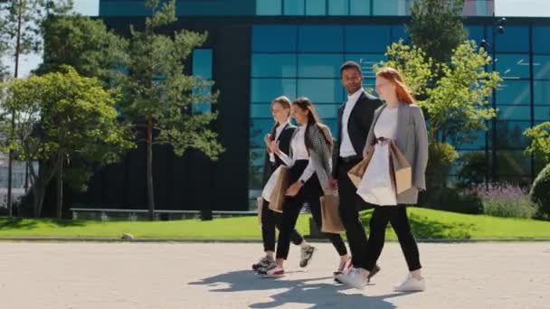 Em um grupo perfeito dia ensolarado de jovens estudantes carismáticos caminhando para sua faculdade moderna eles discutem sobre algo conceito multirracial — Vídeo de Stock