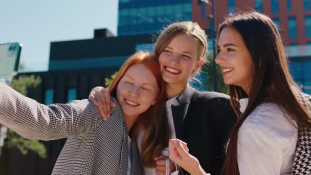 Beautiful with perfect smile ladies multiracial taking some pictures with smartphone beside of a modern architectural building — Stock Video