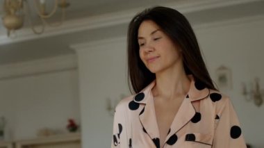 Arkasında avize olan genç ve karizmatik bir kadının yavaşça hareket ettiği bir klip..