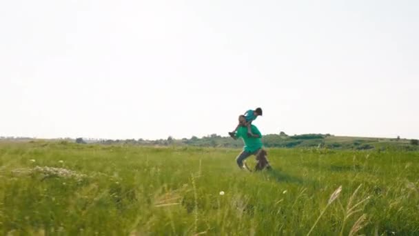 Przed kamerą biegnie szczęśliwy tata ze swoim słodkim małym chłopcem na plecach bawią się swoim słodkim psem angielskim cocker spaniel — Wideo stockowe