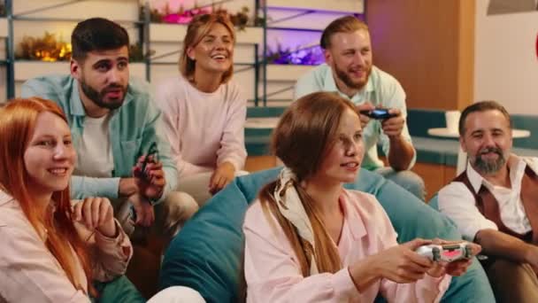 Seis personas están jugando unos contra otros en los videojuegos y se sienten positivas con buena energía en el aire — Vídeo de stock