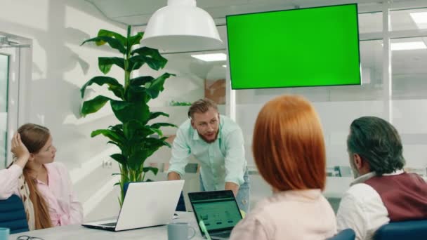 Quatre personnes qui travaillent dur sont dans une salle de bureau moderne et ils tiennent une réunion sur des questions de travail sérieuses — Video