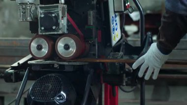 Endüstriyel bölgede koruyucu eldivenli bir fabrika işçisi metali kullanarak güvenlik eldiveni ve teçhizatı takıyor..