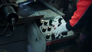 Kameraya yakın endüstriyel imalat işçisinin operatörü, motoru çalıştırmak için yeşil düğmeye basıyor. 4k