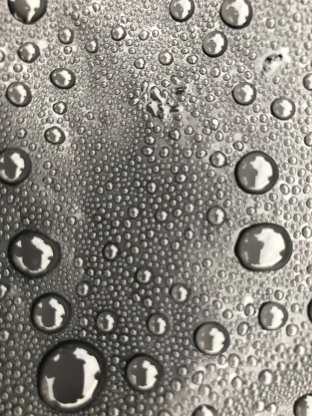 Gotas de água na superfície preta. Gotas de água macro. — Fotografia de Stock