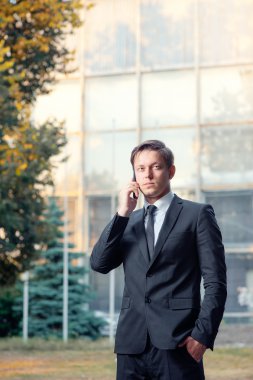 İş adamı cep telefonuyla konuşuyor.