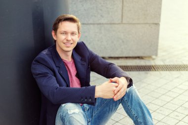 Adam yerde oturuyor.