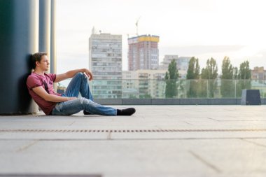 Adam yerde oturuyor.