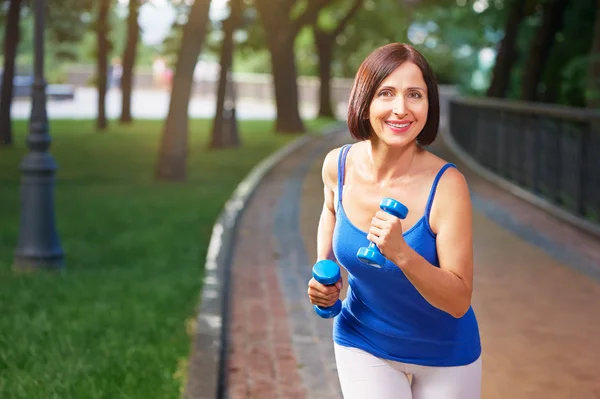 Woman running  with bar bells — Stock Photo, Image